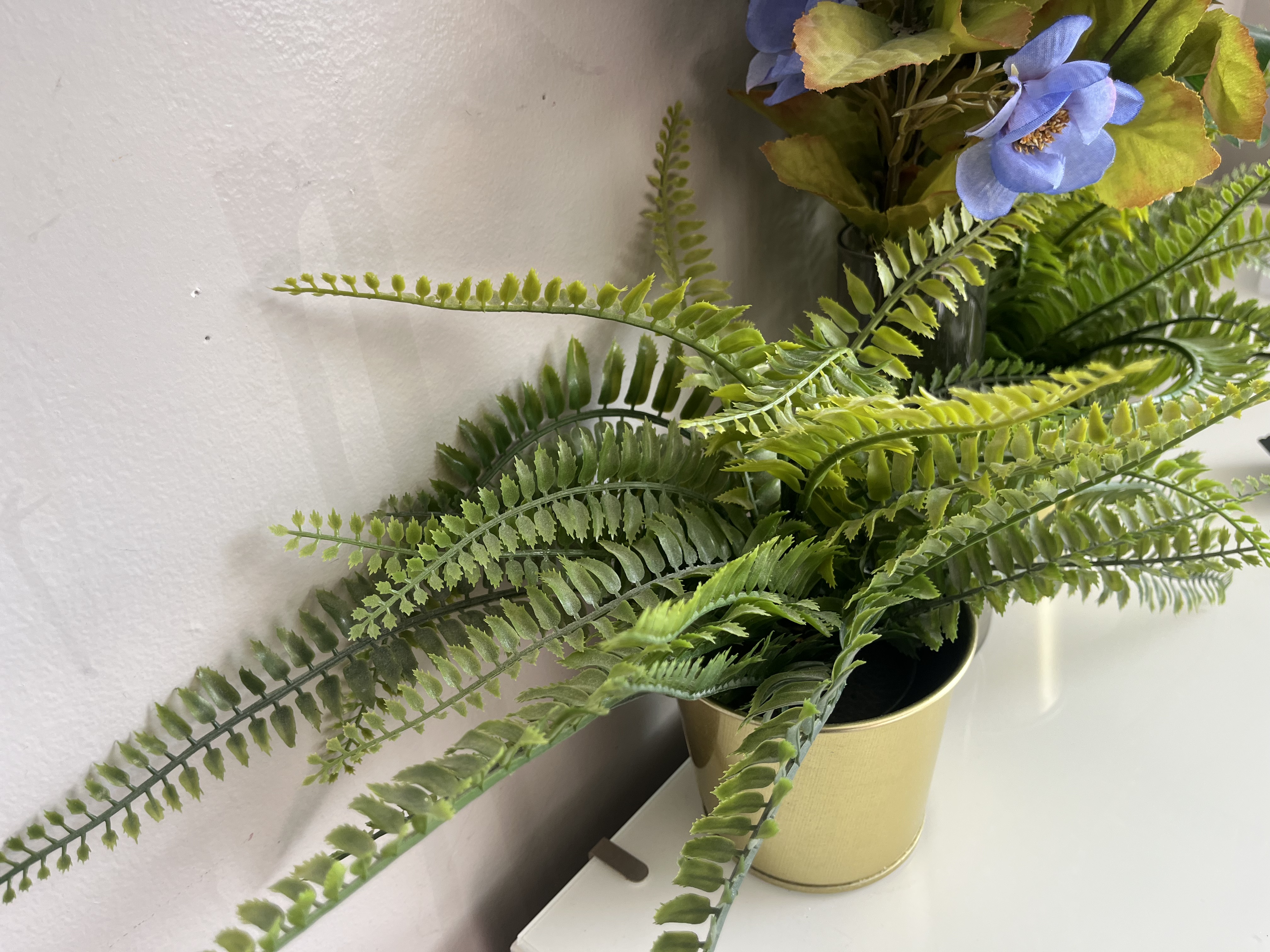 This is the sound of fake plant leaves rustling, producing a light, dry plastic brushing noise with soft, crinkly movements as the leaves shift against each other.